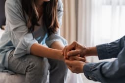 Jeune homme r&eacute;confortant et soutenant une femme triste qui est dans une situation grave