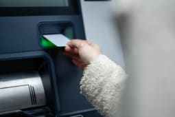 Personne ins�rant une carte de banque dans la fente d'un distributeur automatique de billets