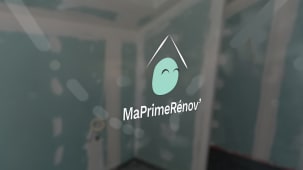 MaPrimeRenov sur une fen&ecirc;tre, en arri&egrave;re-plan flou une maison en travaux..