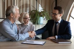 Couple de personnes &acirc;g&eacute;es heureux serrant la main de l'agent immobilier, du notaire, de l'avocat. Homme et femme m&ucirc;rs achetant une maison, une assurance maladie, consultant un professionnel, serrant la main sur les documents.