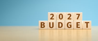 Des cubes de jouet en bois formant le texte BUDGET 2027. 