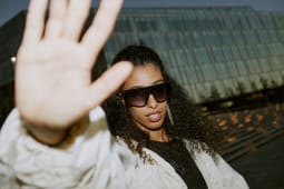 Photo des paparazzi d'une c&Atilde;l&eacute;brit&eacute; f&eacute;minine glamour du Moyen-Orient portant des lunettes de soleil &agrave; la mode, pr&eacute;servant son intimit&eacute; en se cachant avec sa main de la lumi&egrave;re de la cam&eacute;ra des photographes dans la rue la nuit, flash de la cam&eacute;ra, espace de copie