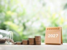 Calendrier de bureau 2027 et pile de pi&egrave;ces.
