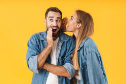 Image d'une femme heureuse chuchotant un secret &agrave; l'oreille d'un homme excit&eacute;