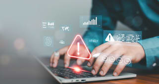 Mains tapant sur un ordinateur portable avec une alerte d'avertissement lumineuse et une interface de tableau de bord de donn&Atilde;es virtuelles. Concept de risque de cybers&eacute;curit&eacute;, d&eacute;tection d'erreurs syst&egrave;me, protection des donn&eacute;es, technologie de surveillance de la s&eacute;curit&eacute; en ligne