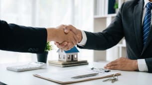 Deux hommes se serrent la main apr&egrave;s une transaction immobili&egrave;re.