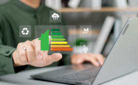 Main d'homme d'affaires utilisant un ordinateur portable avec une &eacute;valuation de l'efficacit&eacute; &eacute;nerg&eacute;tique d'une maison.