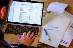 Homme remplissant d&eacute;claration d?imp&ocirc;ts sur ordinateur, dossiers et documents.