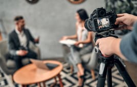 Une journaliste interviewant un homme d'affaires.