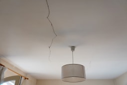 Une fissure visible au plafond au-dessus d'une lampe
