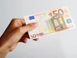 Quelqu'un tient un billet de 50 euros.