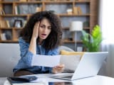 Une femme regardant un document, choquée.