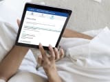 Personne utilisant une tablette pour naviguer sur un site web. Prime d'activit&eacute; CAF