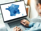 Personne regardant une carte de France colorée sur ordinateur.