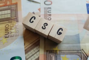 Des cubes en bois avec CSG sur des billets d'euro.