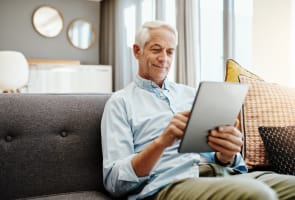 Personne �g�e, tablette et retraite � la maison pour taper des emails, communiquer et lire des nouvelles en ligne. Personne �g�e, technologie et d�tente sur le canap� dans le salon pour le paiement des factures, la vid�o et la lecture d'ebook