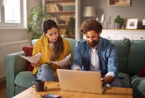 Un couple examine les documents d'assurance vie en ligne.
