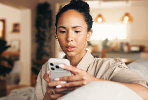 Inqui�tude, femme et lecture avec t�l�phone � la maison pour escroquerie, phishing par email et notification de fraude. Pr�occupation, personne f�minine et mobile pour des fausses nouvelles, paiement suspect et avertissement de virus avec menace de piratage.