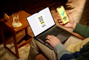Homme payant en ligne avec ordinateur portable et smartphone.
