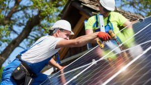 hommes installant des panneaux solaires sur un toit