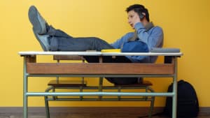 jeune en train de téléphoner depuis un bureau d'écolier