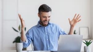 Un homme heureux devant un ordinateur.