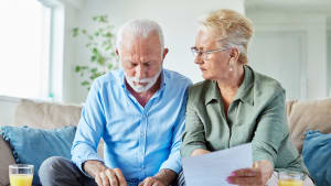 Deux personnes ges regardent un document.