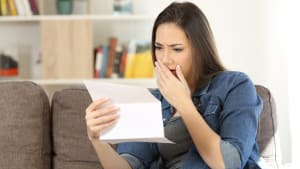 Une femme regarde un document l'air inquiet.