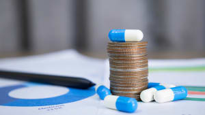 Des m�dicaments et une pile de pi�ces de monnaie.