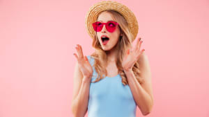 Une femme porte un chapeau et a un air surpris.