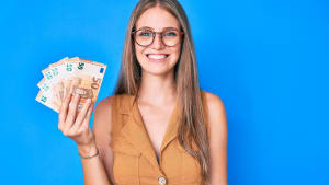 Une femme montre des billets de 50 euros.