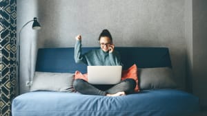 Une femme sur son canap� devant son ordinateur.