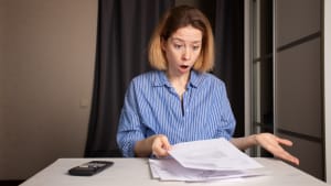 Une femme regarde un document l'air surpris.