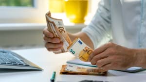 homme comptant des billets