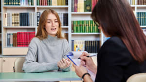 Une jeune femme face  une autre dans une bibliothque
