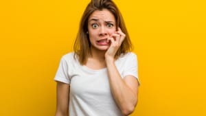 Jeune femme caucasienne naturelle se rongeant les ongles, nerveuse et