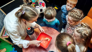 Une enseignante montre une exprience scientifique  des enfants.