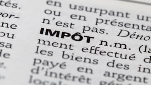 Gros plan sur le mot IMPÔT dans un dictionnaire.