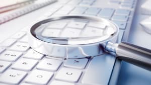 Loupe pose sur un clavier d'ordinateur, recherche de dtails.