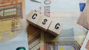 Des cubes en bois avec CSG sur des billets d'euro.