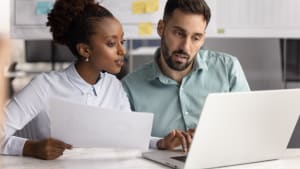 Deux collgues travaillant ensemble sur un document, vrifiant les dtails de l'accord.