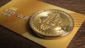 Pièce de Bitcoin dorée sur une carte de crédit.