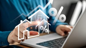 Personne utilisant un ordinateur portable avec des graphiques immobiliers.