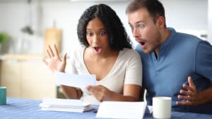 Un couple tonn lisant un relev bancaire dans la cuisine.
