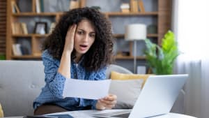 Une femme regardant un document, choquée.