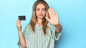 Femme tenant une carte et faisant un geste de refus.