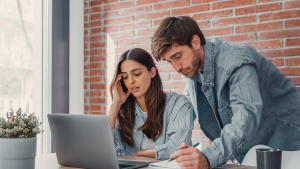 Un couple de millennials regardant leur ordinateur.