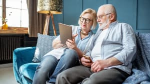 Un couple de personnes ges utilisant une tablette numrique.