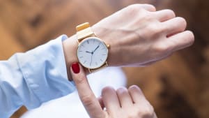 Jeune femme vérifiant l'heure sur sa montre