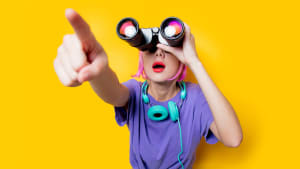 Jeune fille de style dans des vtements violets avec des jumelles sur fond jaune. Vtements de style des annes 1980.